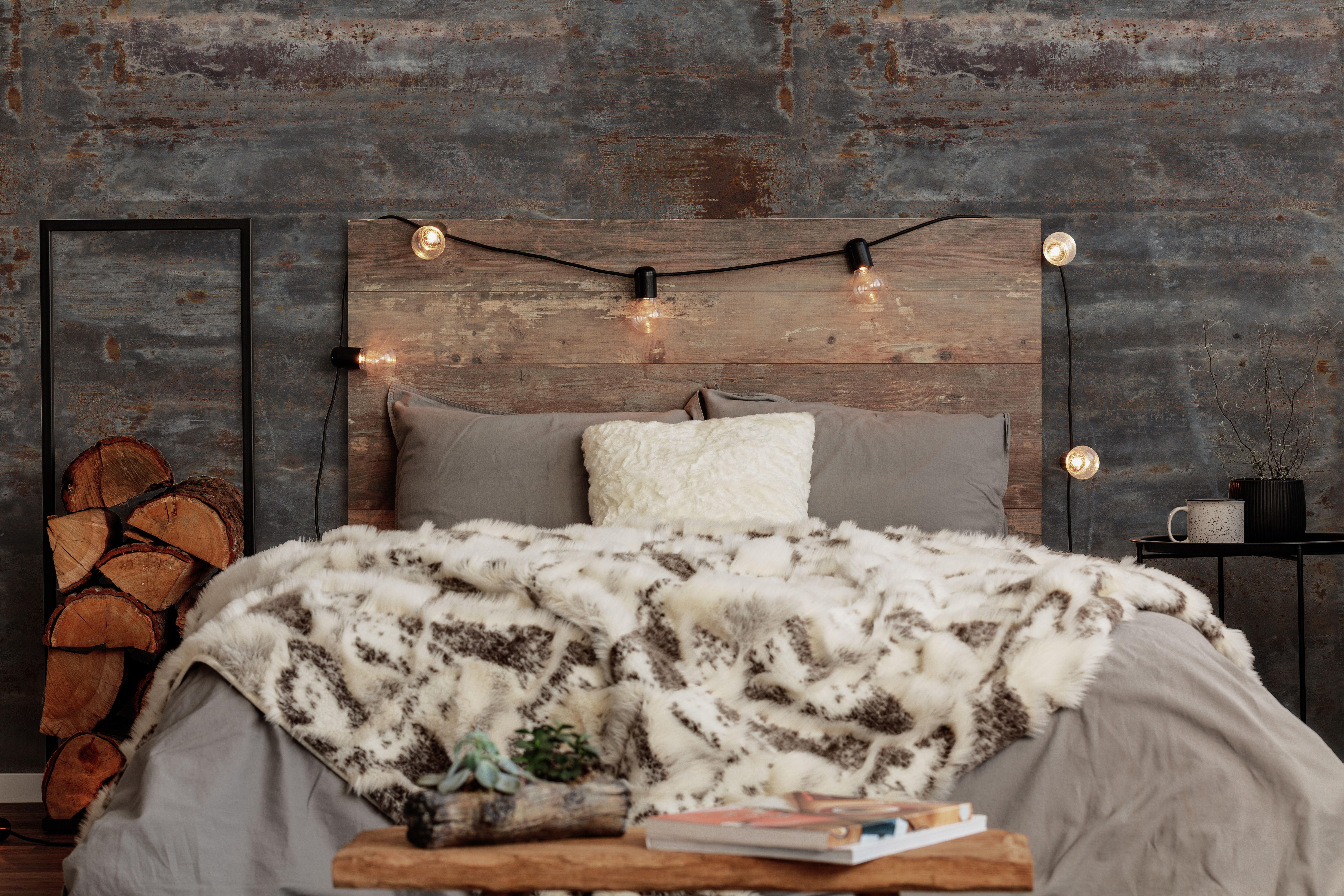 Warm fury blanket on grey duvet on king size bed in front of oxide wall panel